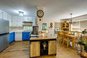 uma cozinha com armários azuis e um relógio na parede em 36-Acre Scaly Mountain Tranquility Lodge em Scaly Mountain