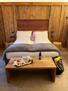 a bed with a table with a tray of food on it at Hotel Ortles Dolomiti Walking & Spa in Cogolo