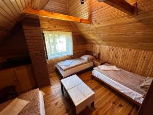 an attic room with two beds and a window at Gościniec Pod Dębami in Puchły