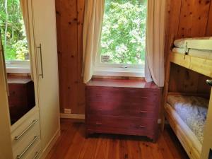 1 dormitorio con ventana, vestidor y cama en Idyllic lakeside cabin (hytte), en Horten