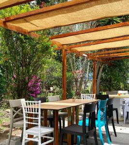 a wooden table and chairs under a wooden pergola at Casa Skema - Garden in Quito