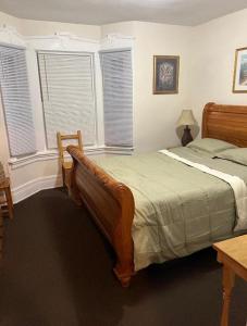 una camera con un grande letto e due finestre di Victorian Palace-Pecan Room a East Orange