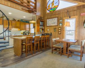 a kitchen with wooden walls and wooden tables and chairs at 7026 - Southwind by Resort Realty in Rodanthe