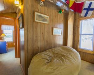a bedroom with a bed in a wooden wall at 7026 - Southwind by Resort Realty in Rodanthe