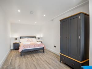 um quarto com uma cama e um grande armário preto em Cleggan Pierside Apt 1 em Cleggan
