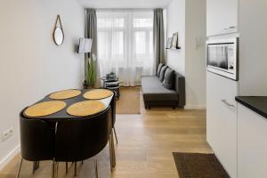 uma cozinha e sala de estar com mesa e cadeiras em R73 Apartments by Domani Hotels em Antuérpia
