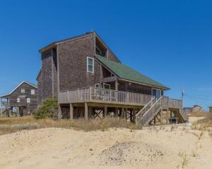 a large wooden house on a beach next to the sand at 7026 - Southwind by Resort Realty in Rodanthe