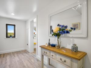 a vase of flowers on a dresser in a room at Cleggan Pierside Apt 1 in Cleggan