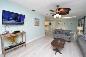 a living room with a couch and a tv on a wall at HIDDEN OASIS Spacious Pool Home with Florida Room and Hot Tub in Palm Coast