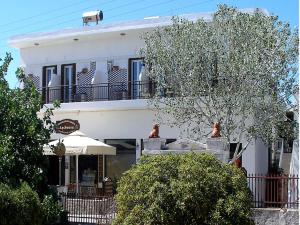 ein weißes Gebäude mit Balkon darüber in der Unterkunft Arethousa in Plaka Milos