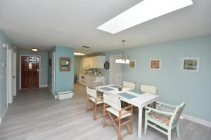 a dining room and kitchen with a table and chairs at HIDDEN OASIS Spacious Pool Home with Florida Room and Hot Tub in Palm Coast