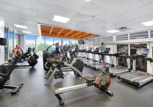 a gym with several tread machines and people in the gym at Good Morning Beautiful! Direct Water Views in Miami