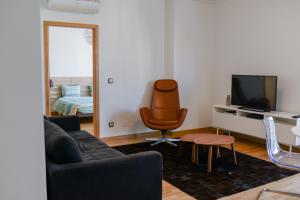 a living room with a couch and a chair and a television at Lisbon Brown Cozy Apartment in Lisbon