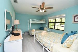 a bedroom with a bunk bed and a ceiling fan at HIDDEN OASIS Spacious Pool Home with Florida Room and Hot Tub in Palm Coast +48 photos