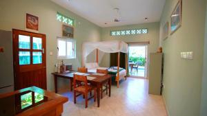 The Pool House & The Colobus House, Bella Seaview, Diani Beach, Kenya في شاطئ دياني: غرفة معيشة مع طاولة وغرفة نوم