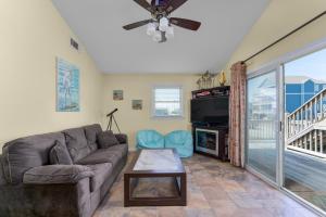 a living room with a couch and a tv at 7039 - A Wave From It All by Resort Realty in Rodanthe