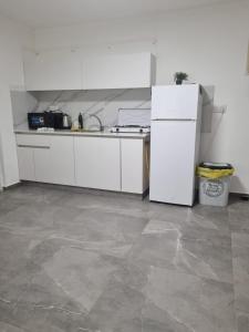 a kitchen with white cabinets and a refrigerator at דירה בסטייל in Eilat