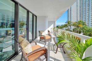a balcony with chairs and tables on a building at Sea Forever! Miami Skyline And Water Views in Miami