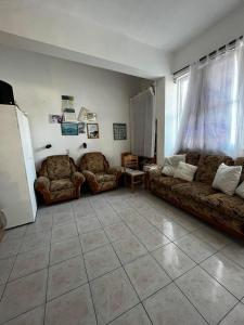 een woonkamer met banken en een tegelvloer bij Selena Rooms in Agia Galini