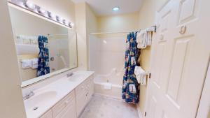 a bathroom with a sink and a shower and a mirror at Beautiful 2BR 2BA Lakeside Villa with Lake Views in Pawleys Island +19 photos
