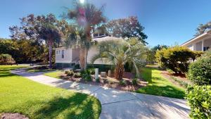 a house with palm trees and a driveway at Beautiful 2BR 2BA Lakeside Villa with Lake Views in Pawleys Island