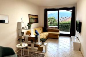 a living room with a couch and a large window at Hygge Holiday House in Luino