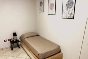 a small bedroom with a bed and a side table at Hygge Holiday House in Luino