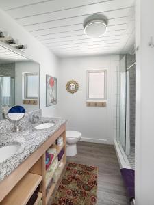 a bathroom with two sinks and a toilet at Folly Vacation Perfect Purple Palace Apt C in Folly Beach