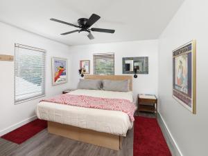 a bedroom with a bed and a ceiling fan at Folly Vacation Perfect Purple Palace Apt C in Folly Beach