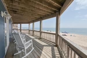 a porch with white chairs on the beach at 7048 - Tide Song by Resort Realty in Rodanthe