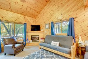 a living room with a couch and a chair and a television at Detroit Lakes Cabin Rental on Long Lake! in Detroit Lakes