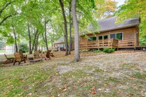 a log cabin with a picnic table and benches at Detroit Lakes Cabin Rental on Long Lake! in Detroit Lakes