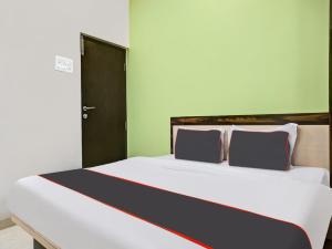 a bedroom with a large white bed with two pillows at Collection O Hotel Pachratna in Chakan