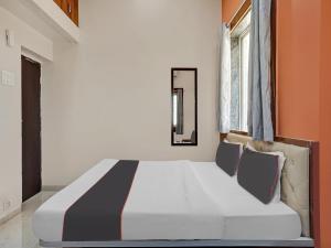 uma cama grande num quarto com laranja e branco em Collection O Hotel Pachratna em Chākan