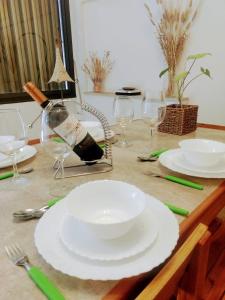 Departamento Mamá Lucia في غوايمالين: طاولة مليئة بالأطباق البيضاء وكؤوس النبيذ