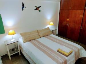 a bedroom with a bed with two night stands and two lamps at Departamento Mamá Lucia in Guaymallen