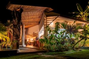 a house with a porch at night with plants at El Rio Hotel in Doradal