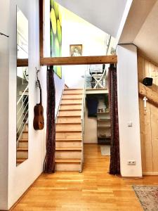 uma escada numa casa com um violino na parede em Stadtoase mit traumhaftem Ausblick em Linz