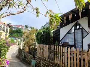 een houten hek voor een huis bij Cleverlearn's Homestay & Coffee in Ấp Ða Lợi