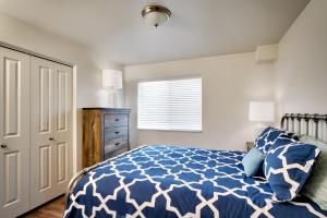 Un dormitorio con una cama azul y blanca y una ventana en 2G New Moab RedCliff Condo, Pool & Hot Tub en Moab