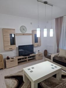 sala de estar con sofá, TV y mesa en Villa Rina, en Bitola