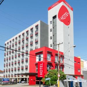 I-Hotel Piracicaba في بيراسيكابا: علامة وقوف أمام مبنى احمر وبيضاء