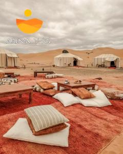 a desert with tents and pillows on the ground at Arena y Sol Merzouga Camp in Merzouga