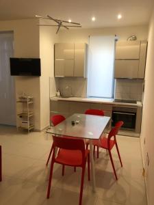 une cuisine avec une table à manger et des chaises rouges dans l'établissement Casa Vacanze Il Divano Rosso, à Foligno