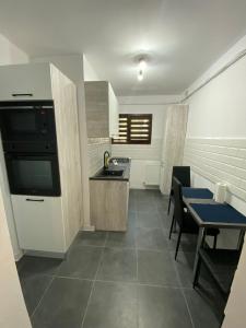 a kitchen with a table and a sink and a stove at VD Apartament 2 in Constanţa