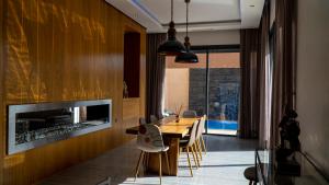 a dining room with a table and a fireplace at Villa HAW Marrakech in Marrakesh