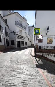 a street with a parking sign next to a building at Tiny Spanish House in Casares