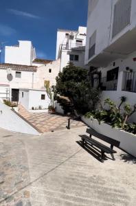 a bench sitting in front of a building at Tiny Spanish House in Casares