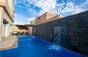 een zwembad voor een bakstenen muur bij Villa HAW Marrakech in Marrakesh