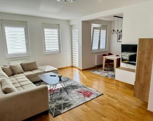 ein Wohnzimmer mit einem Sofa und einem Tisch in der Unterkunft Apartman Pale Jahorina in Pale